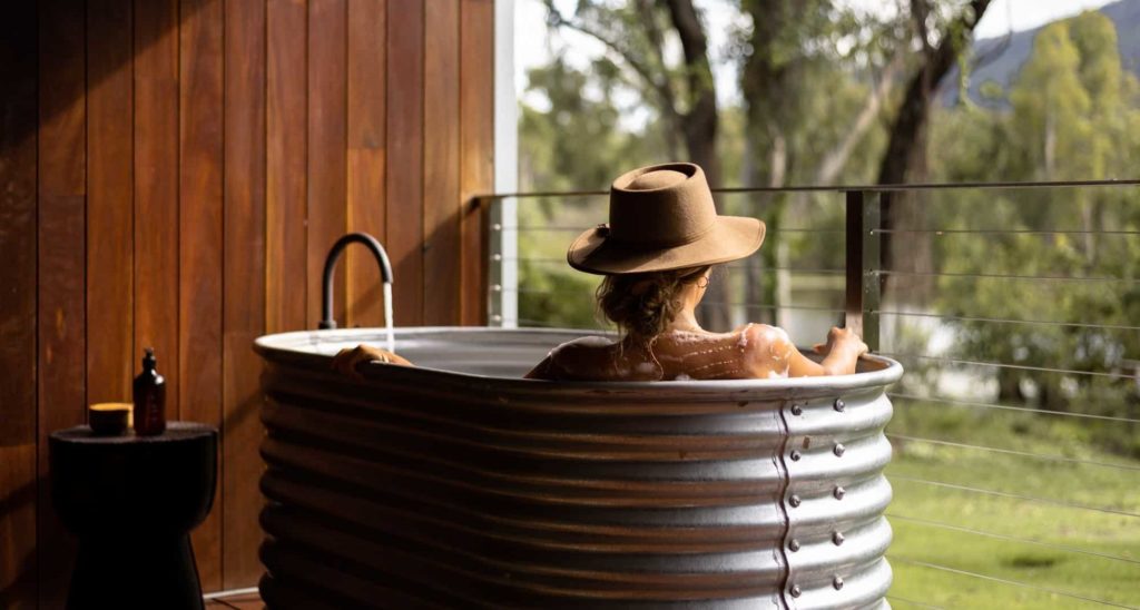 Mt Mulligan Lodge Woman in rustic bathtub admiring the Outback view